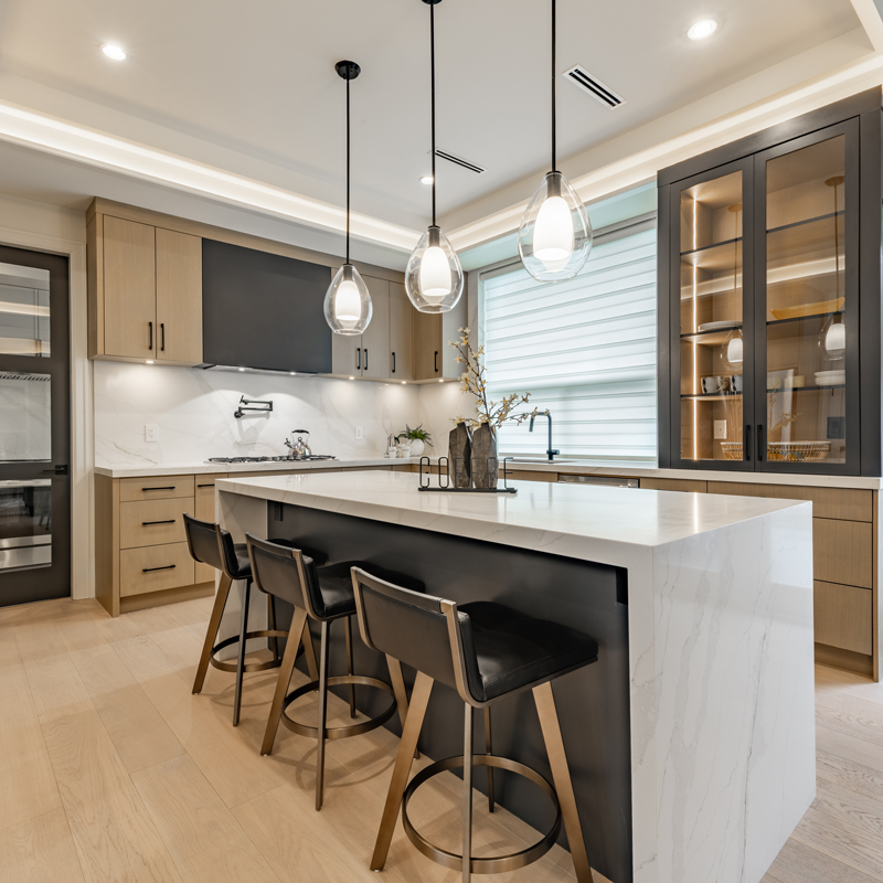 a nice kitchen with an island with overhead lighting